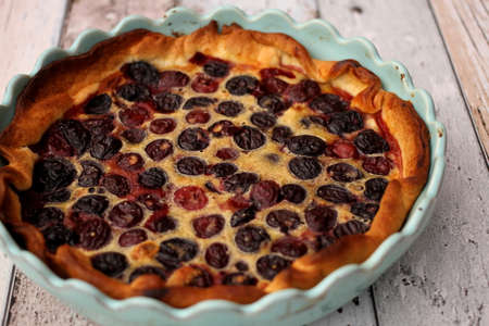 Raw cherries and homemade cherry pie on wooden tableの写真素材