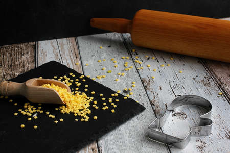 Christmas pastry cutter glove with rolling pin and yellow sugar stars on slate boardの写真素材