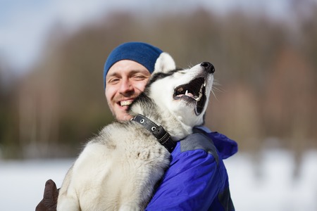 Happy man with a husky at winter time