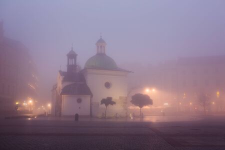 Old church on the market square in Krakow at morning fog, Polandの写真素材