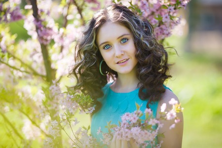 Portrait of beautiful young girl in the bushes magnolia
