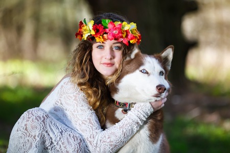 Portrait of a beautiful girl with one husky dog in a forest at spring timeの写真素材