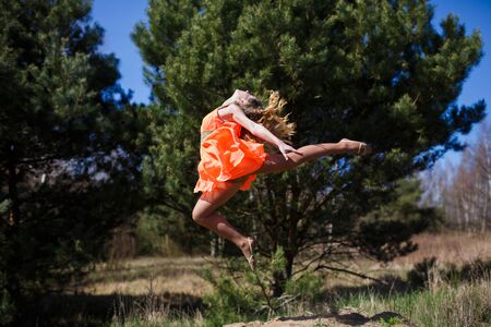 Young gymnast doing exercises in a forest at spring timeの写真素材