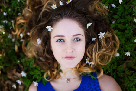 Portrait of a beautiful girl with flowers in her hair at spring timeの写真素材