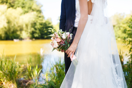 Groom holding bouquet with your bride on the wedding dayの写真素材