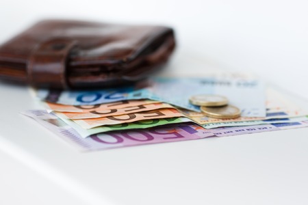 Banknotes, coins and wallet on the white background