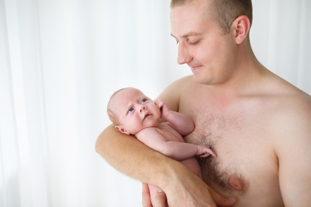 Father holding his one month old son in studio