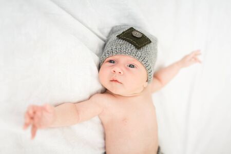 Portrait of an one month boy dressed in a grey hat on the white backgroundの写真素材