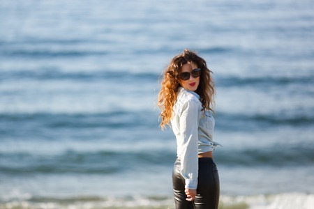 Young woman walking on the seacoast at autumn timeの写真素材
