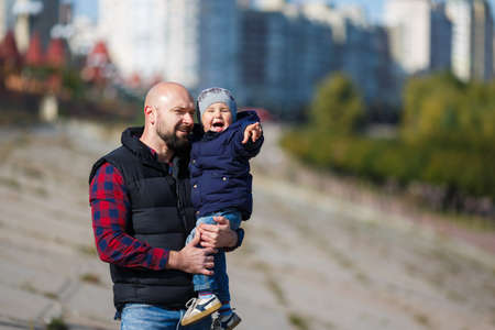Father and son walking in the city at autumn time