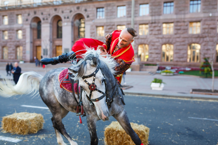 Kiyv, Ukraine - October 10 2015: The show of riding, ukrainian cossacks dressed in traditional costumes show their skills of riding on the central street Khreschatic in autumnのeditorial素材