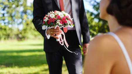 The groom holding wedding bouquet for his bride in the wedding dayの写真素材
