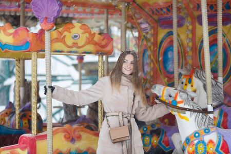 Young woman enjoys the winter holiday on the carouselの写真素材