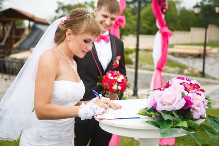 The bride signs a document on the wedding ceremonyの写真素材