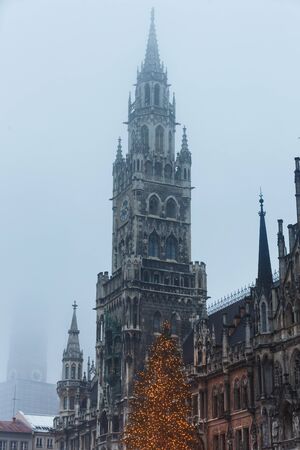 Tower of City Hall with christmastree on foreground at misty eveningのeditorial素材
