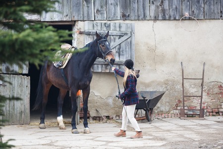 The rider and horse going out from the stableの写真素材