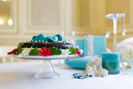Wedding chocolate cake decorated with stuff on a white tableの写真素材