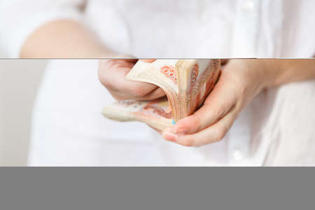 Hand of woman holding five thousand rubles banknotes on the white backgroundの写真素材