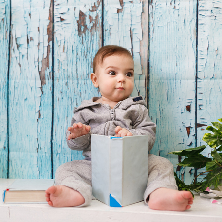 Portrait of the little boy with the books in studio