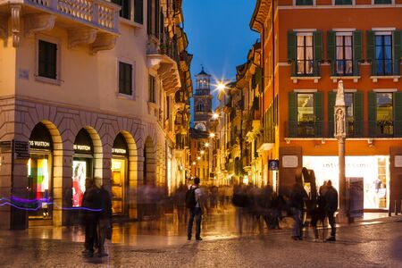 Verona, Italy - May 07 2016: Some people walking on the Bra square against the backdrop of the Lamberti tower, evening timeのeditorial素材