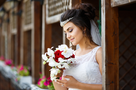 Beautiful bride with bouquet against the wooden backgroundの写真素材