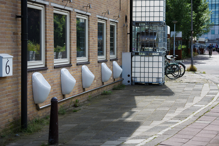 Amsterdam, Netherlands - July 02 2016: Urinals on the wall of building on the Dijksgracht street, summer timeのeditorial素材