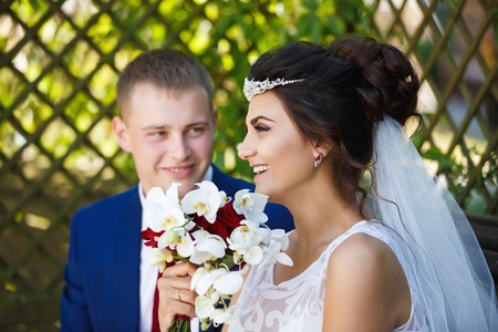 Wedding couple sitting in a wooden garden houseの写真素材