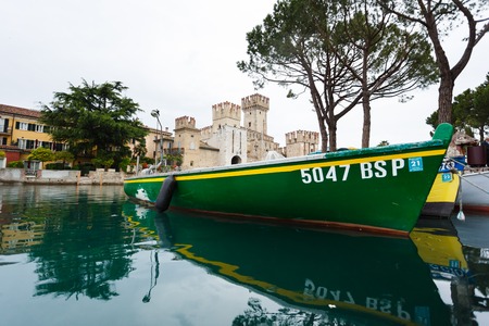 Sirmione, Italy - May 09 2016: Castle of Scaligero with a boat on the foreground at rainy weatherのeditorial素材