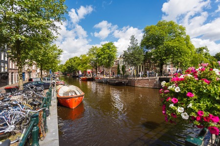 Amsterdam, Netherlands - July 02 2016: Parked boats and bikes on a streets of Amsterdam, sunny dayのeditorial素材