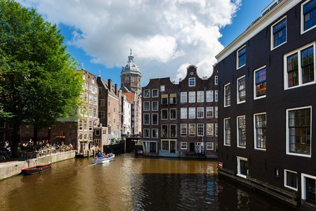 Amsterdam, Netherlands - July 02 2016: The traditional Dutch houses with reflection in water, view from Oudezijds Voorburgwal street at sunny dayのeditorial素材
