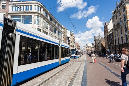 Amsterdam, Netherlands - July 03 2016: Trams in traffic on a street of the city, summer timeのeditorial素材