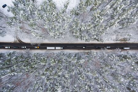 Road through the winter forest, view from above