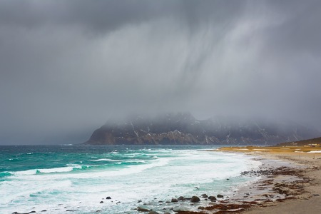 Dark rainy clouds over the Uttakliev beach in Lofoten islands, winter timeの写真素材