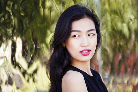 Asian young woman against the mirror wall outdoorsの写真素材