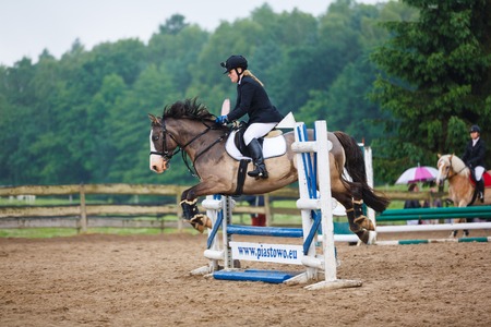 Elblag, Poland - June 25 2017: Horse rider is jumping over obstacles in the arena during the amateur...