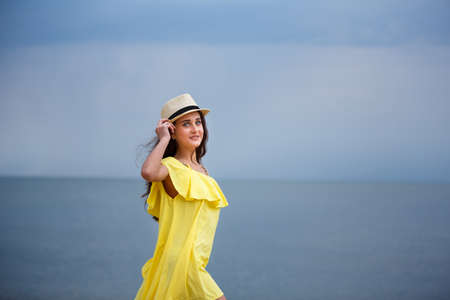 Young beautiful girl is walking on the beach in eveningの写真素材