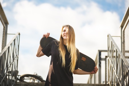 Teenage girl with skateboard in a skateparkの写真素材