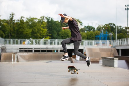Young female skateboarder practicing in skatepark outdoorsの写真素材
