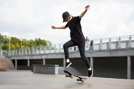 Young female skateboarder practicing in skatepark outdoorsの写真素材