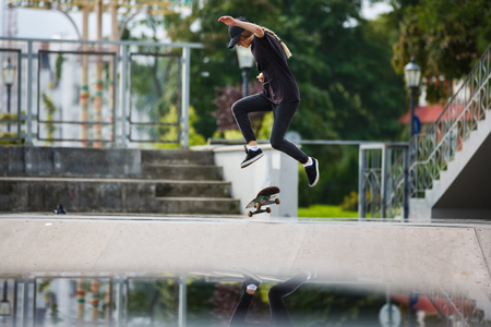 Young female skateboarder practicing in skatepark outdoorsの写真素材