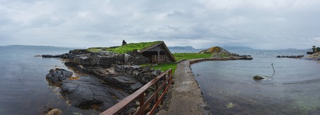 Abandoned wooden house on the stony shore in rainy weatherの写真素材