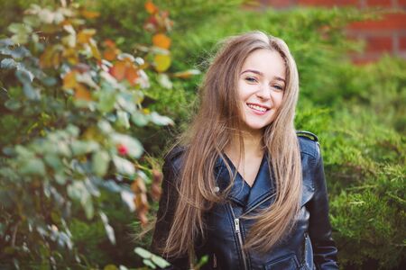 Portrait of the cheerful young girl in a forest