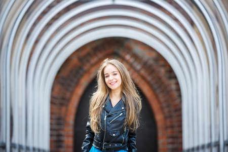 Portrait of the cheerful young girl in a glass arch