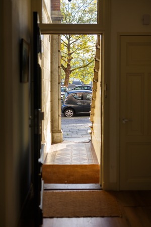 View of the street through the open door of the house in autumnの写真素材