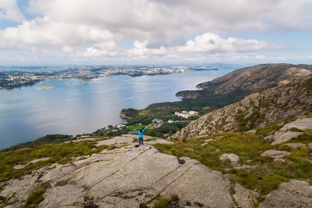 Woman is hiking on the top of a mountain in Norwayの写真素材