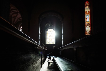 The sunlight through the window illuminates the prayer in the churchの写真素材
