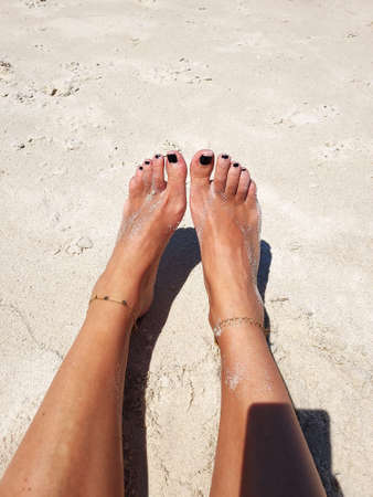 BARE FEET ON THE SAND OF THE BEACHの写真素材