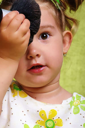Beautiful young girl with a cosmetic brushの写真素材