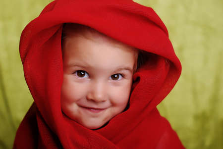 2 year old smiling child in a red scarfの写真素材