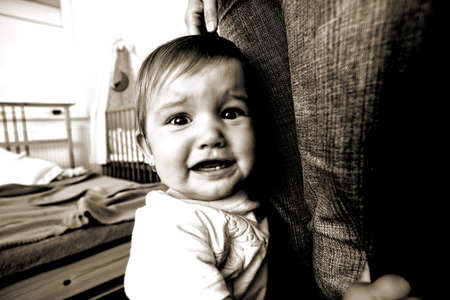 Small frightened baby with his mother in bedroomの写真素材